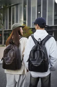 Vue street style de sacs à dos urbains en similicuir poli marron foncé et noir