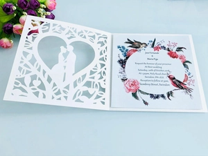 Laser cut wedding invitation with heart silhouette and colorful floral inner page detail