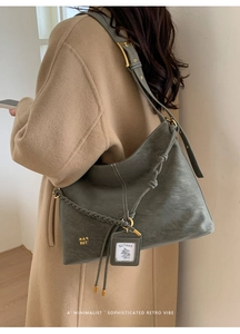 Detail view of large grey-green retro Hobo bag with textured leather and gold logo