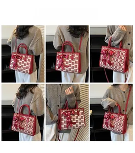 Detail of red wedding tote bag featuring Xi character jacquard and silk bow decoration