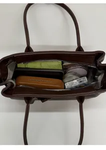 Interior view of brown tote bag showing capacity for tablets and daily essentials