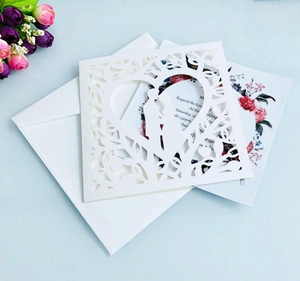 Detail of laser-cut heart and couple silhouette on a cream white wedding invitation