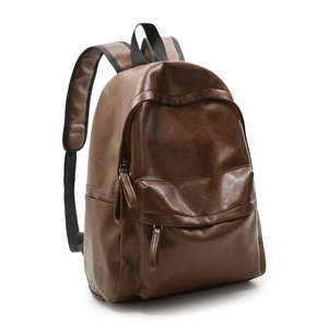 Détail d'un sac à dos vintage en cuir marron avec grand compartiment et poche latérale