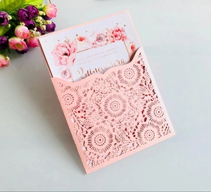 Detailed laser-cut floral pattern on pink wedding invitation with rose printed inner card