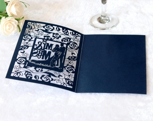 Detail of laser-cut navy blue wedding invitation with Mr & Mrs floral pattern