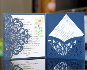 Detail of laser-cut navy blue invitation cover with elegant white floral inner card