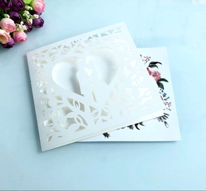 Laser cut wedding invitation detail featuring a cream heart and romantic couple silhouette