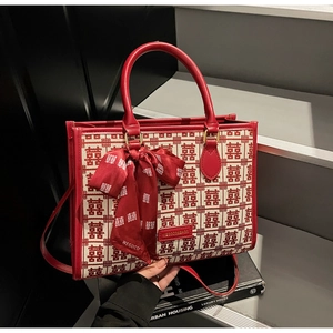 Detail of red wedding tote bag featuring traditional pattern and elegant ribbon bow charm
