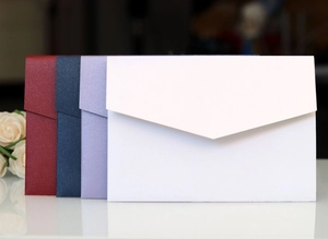 Detail of luxury pearl paper envelopes in deep red and navy for wedding invitations