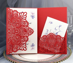 Detail of red laser-cut floral wedding invitation with white insert card and pearl paper