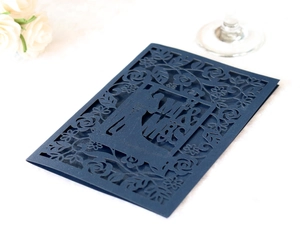 Detail of laser-cut navy blue wedding invitation with MR & MRS and floral patterns