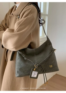 Detail of the woven shoulder strap and textured leather of the vintage hobo bag