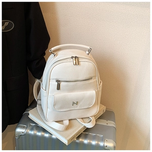 Detail of white lychee leather mini backpack with silver N logo and metal zippers
