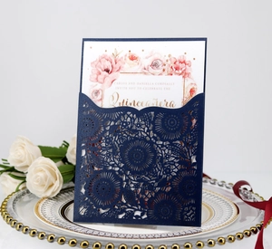 Close-up of laser-cut hollow pattern on burgundy invitation with floral card insert