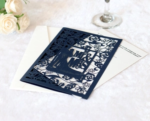 Detail of navy blue laser-cut wedding invitation featuring Mr & Mrs floral pattern