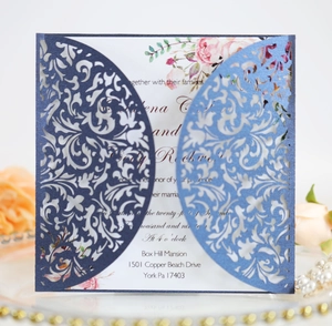 Detail of laser-cut navy blue wedding invitation with intricate floral hollow patterns