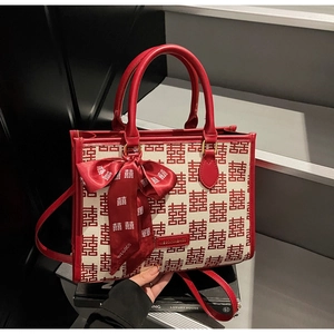 Detail of red wedding tote bag with double happiness pattern and silk ribbon bow