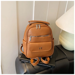Detail of caramel lychee grain leather mini backpack with magnetic flap and metal logo