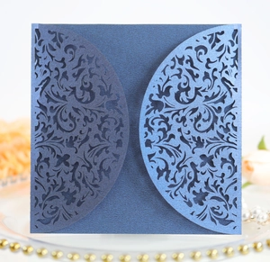 Detail of laser-cut European floral patterns on dark blue pearlescent wedding card covers