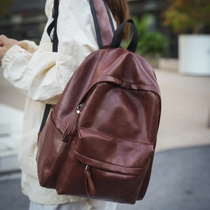 Détail du sac à dos vintage en cuir PU marron foncé avec poches zippées latérales