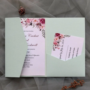 Close-up of sage green pocket wedding invitation with watercolor floral cards and RSVP