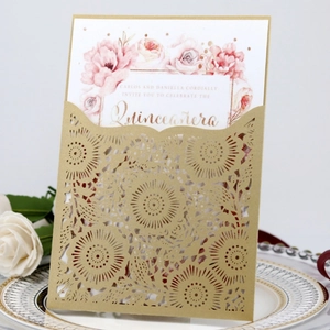 Macro detail of laser-cut sunburst pattern on burgundy invitation with white floral card
