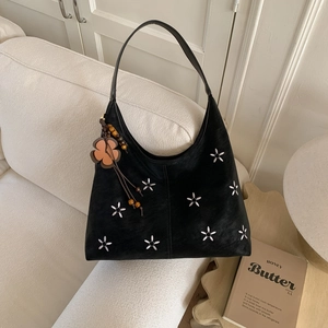Détail du sac cabas en suédine noire avec broderies florales et pompon perlé