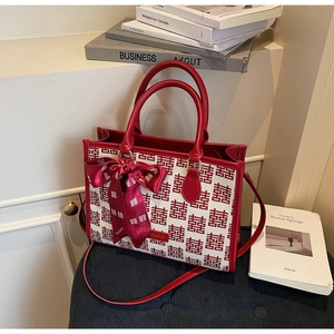 Detail of red wedding tote bag with Xi character pattern and decorative silk scarf