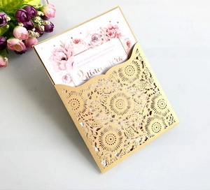 Macro view of laser-cut floral wedding invitation with pink rose card and gold finish