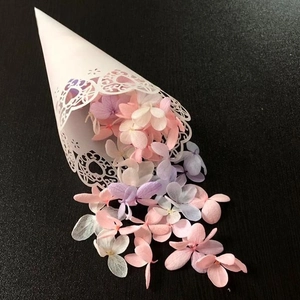 Laser cut white paper wedding cones with floral patterns and dried flower petals