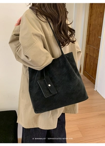 Close-up of matte black suede tote bag with a small matching pouch in minimalist style