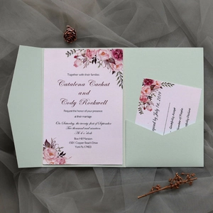 Detailed view of mint green laser-cut wedding invitation set with floral card and RSVP note