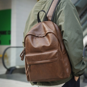 Détail d'un sac à dos vintage en cuir PU marron avec texture et longues tirettes de zip