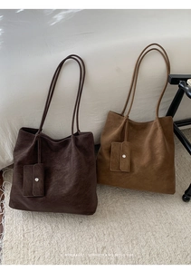 Close-up of retro minimalist large tote bags in brown and camel with matching pouches