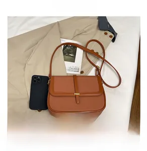 Close-up of brown vintage crossbody bag with woven texture and gold metal buckle detail