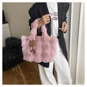 Détail du sac cabas en fausse fourrure rose avec breloque ours et texture douce