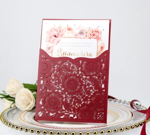 Detailed laser-cut floral pattern on burgundy cardstock with elegant gold lettering