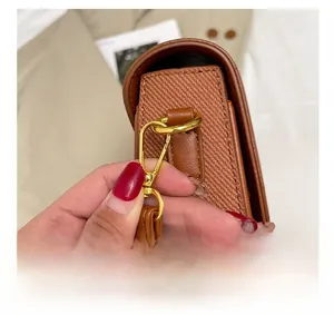 Detail of premium golden metal hardware and brown twill fabric on the shoulder bag