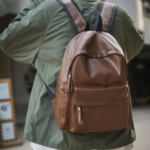 Vue arrière d'un mannequin portant un sac à dos vintage en similicuir marron en ville