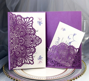 Detailed laser-cut pattern on navy blue wedding invitation with floral insert card