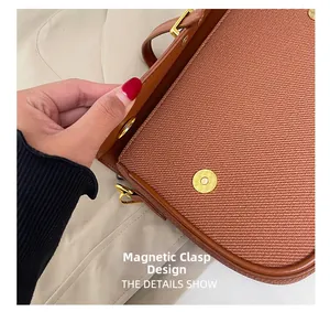 Detail of magnetic snap design on brown crossbody bag with high-quality gold hardware buckle