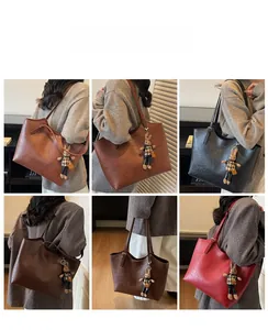 Detail view of large faux leather tote bags in multiple colors with rabbit doll pendant