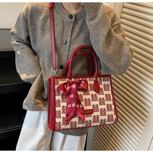 Detail of red wedding tote bag with Xi character jacquard and decorative bow ribbon