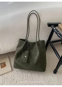 Detail of dark green retro tote bag with suede texture and mini clip-on pouch