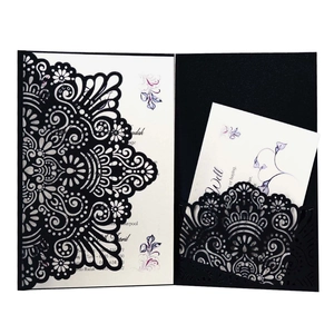 Detail of laser-cut black mandala invitation card with elegant white floral inner sheet