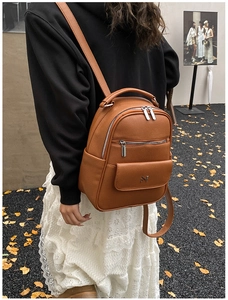 Brown lychee grain faux leather backpack with silver zippers and metal logo detail