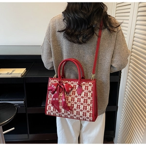 Red festive tote bag with traditional double happiness pattern worn over the shoulder