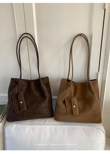 Detail of minimalist tote bags in dark brown and caramel suede with small pouches