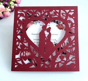 Détail du faire-part de mariage rouge découpé au laser avec silhouette de cœur