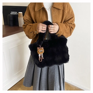 Détail du sac cabas noir en fausse fourrure avec pendentif peluche et texture douce
